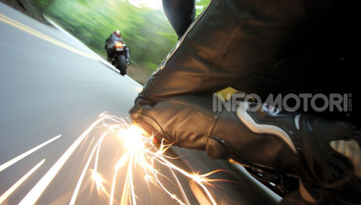 Pilota ginocchio a terra moto su strada